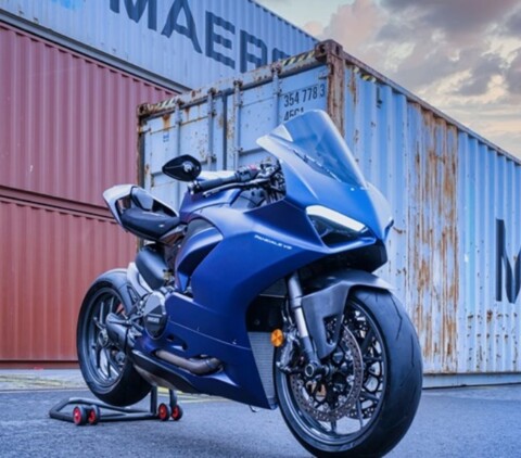 Schwarze Ducati Panigale vor Containern